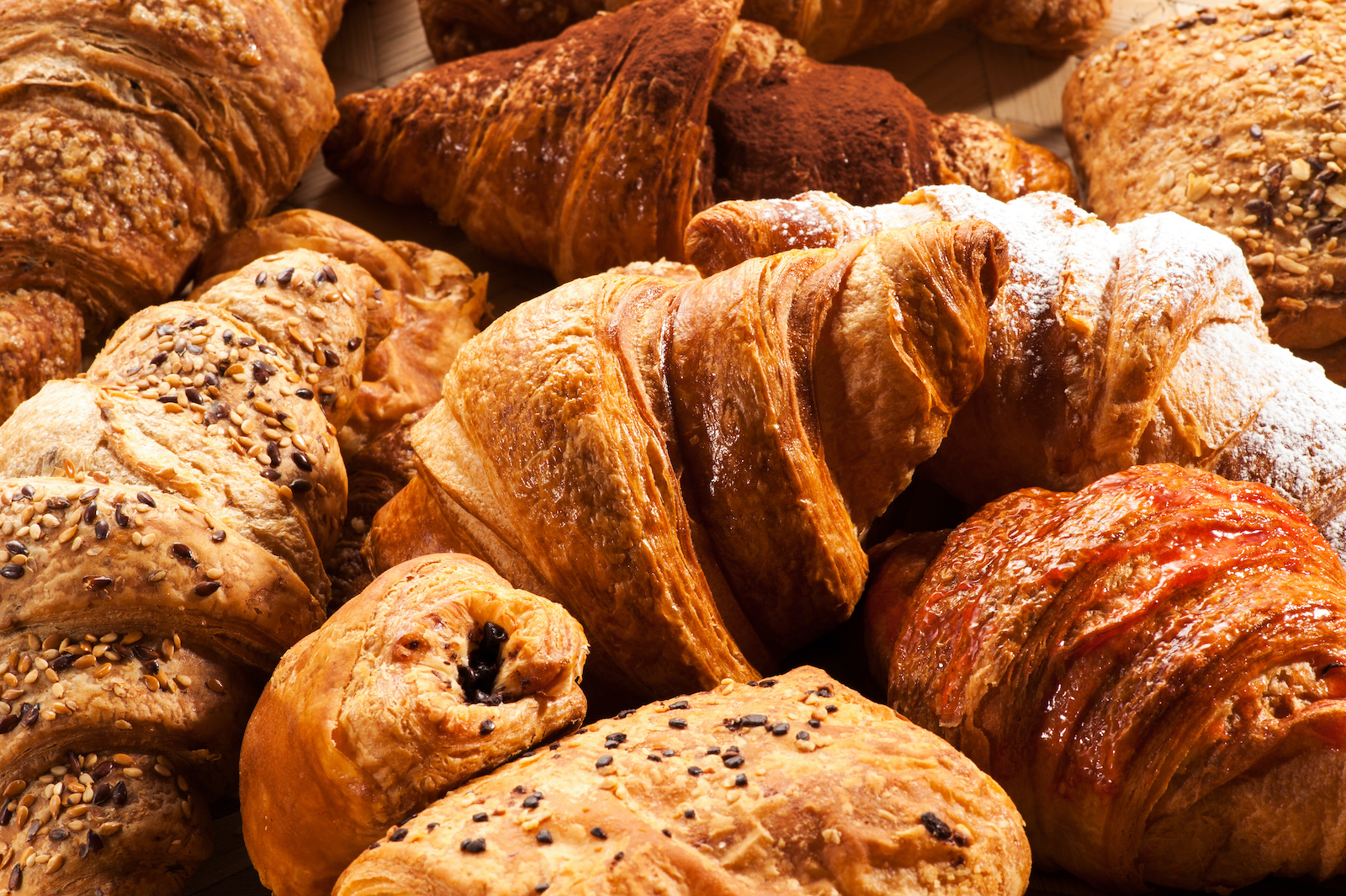 Various delicious pastries and croissants piled together.
