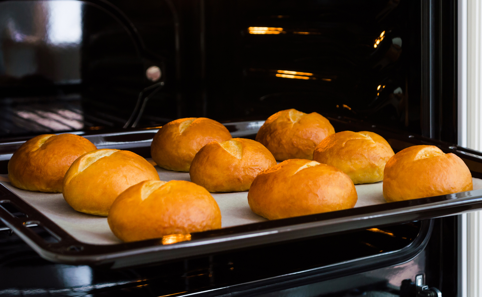 Freshly baked bread rolls in an oven.